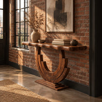 Wood console table with a wavy edge top on a layered arc base in an industrial loft entryway with exposed brick