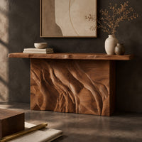Corner detail of console table with a slab top on a deeply carved block base beside wood, brass and linen samples