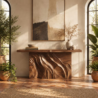 Console table with a slab top on a deeply carved block base in a bright entryway with arched windows and plants