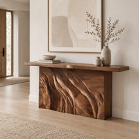 Console table with a slab top on a deeply carved block base in a Scandinavian entryway with white walls