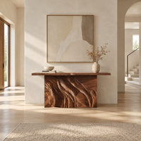 Console table with a slab top on a deeply carved block base in a bright open plan entryway