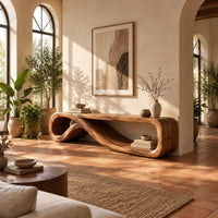 Low tv stand formed from one curling ribbon of wood in a bright living room with arched windows and plants