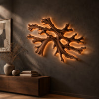 Coral shaped branching wall light with a warm halo of glow behind it, three-quarter view showing the grain