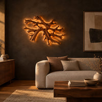 Coral shaped branching wall light with a warm halo of glow behind it in a dark living room at golden hour