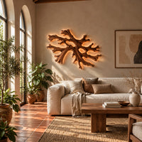 Coral shaped branching wall light with a warm halo of glow behind it in a bright living room with arched windows and plants