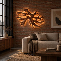 Coral shaped branching wall light with a warm halo of glow behind it in an industrial loft living room with exposed brick