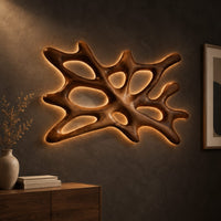 Branching wooden wall sconce with oval openings and a halo of light, three-quarter view showing the grain