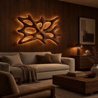 Branching wooden wall sconce with oval openings and a halo of light in an evening living room with walnut wall paneling