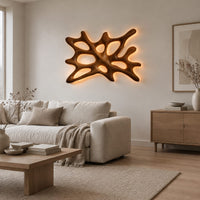 Branching wooden wall sconce with oval openings and a halo of light in a Scandinavian living room with white walls