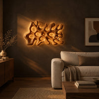 Wide wall sconce shaped like branching coral with pierced openings in a dark living room at golden hour