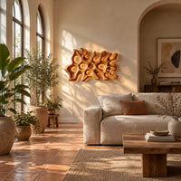 Wide wall sconce shaped like branching coral with pierced openings in a bright living room with arched windows and plants