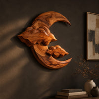 Carved wood crescent moon wall art with two cloud shapes across its face, three-quarter view showing the carved depth