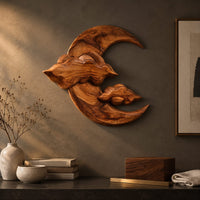 Detail of carved wood crescent moon wall art with two cloud shapes across its face beside wood, brass and linen samples