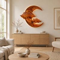 Carved wood crescent moon wall art with two cloud shapes across its face above a light oak sideboard in daylight
