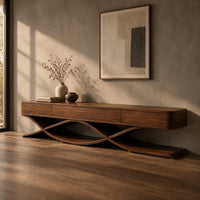 Corner detail of long low tv stand with three front panels on crossing ribbon legs beside wood, brass and linen samples