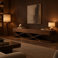Long low tv stand with three front panels on crossing ribbon legs in an evening living room with walnut wall paneling