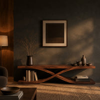 Low open tv stand with curved ribbons crossing in an x shape in a dark living room at golden hour