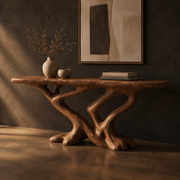 Console table with a slab top on crossing limbs and root style feet, three-quarter view showing the grain