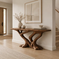 Console table with a slab top on crossing limbs and root style feet in a Scandinavian entryway with white walls