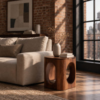 Cube shaped side table with large oval cut outs and softened edges in an industrial loft living room with exposed brick