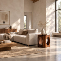 Cube shaped side table with large oval cut outs and softened edges in a bright open plan living room
