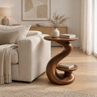 Curling swirl side table with a wide top and a small nested disc shelf in a Scandinavian living room with white walls