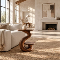 Curling swirl side table with a wide top and a small nested disc shelf in a bright open plan living room