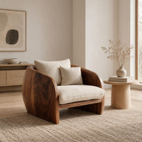 Barrel chair with curved solid wood sides and a deep cream seat cushion in a Scandinavian living room with white walls