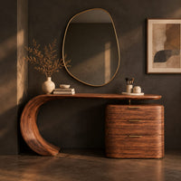 Corner detail of makeup vanity with a sweeping curved leg and a block of three drawers beside wood, brass and linen samples