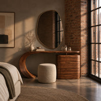 Makeup vanity with a sweeping curved leg and a block of three drawers in an industrial loft bedroom with exposed brick
