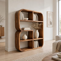 Bookshelf with a thick curved frame and open cubbies of mixed sizes in a Scandinavian living room with white walls