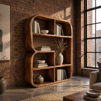 Bookshelf with a thick curved frame and open cubbies of mixed sizes in an industrial loft living room with exposed brick