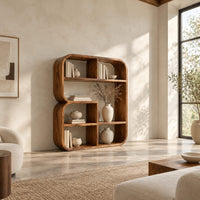 Bookshelf with a thick curved frame and open cubbies of mixed sizes in a bright open plan living room