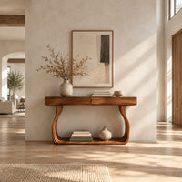Slim console table on bowed sculpted legs joined by a wide floor rail in a bright open plan entryway