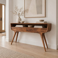 Curved console table with two drawers, open shelf and tapered legs in a Scandinavian entryway with white walls