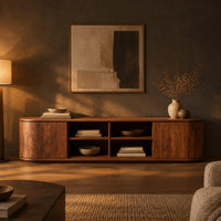 Long tv stand with curved ends, solid end panels and four open center cubbies in a dark living room at golden hour