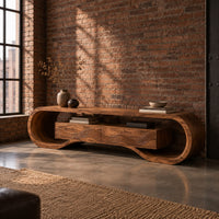 Tv stand with a looping curved frame and a wave carved center box in an industrial loft living room with exposed brick