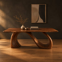 Dining table with a slim top on a looping curved ribbon base in a dark studio against a charcoal plaster wall