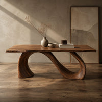 Corner detail of dining table with a slim top on a looping curved ribbon base beside wood, brass and linen samples