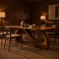 Dining table with a slim top on a looping curved ribbon base in an evening dining room with walnut wall paneling