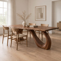 Dining table with a slim top on a looping curved ribbon base in a Scandinavian dining room with white walls