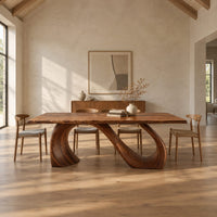 Dining table with a slim top on a looping curved ribbon base in a bright open plan dining room