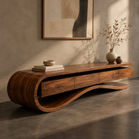 Corner detail of low tv stand with a curled end and a wavy ribbon base beside wood, brass and linen samples