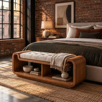 Curved bench with a tufted seat cushion and two open cubbies below in an industrial loft bedroom with exposed brick