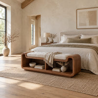 Curved bench with a tufted seat cushion and two open cubbies below in a bright open plan bedroom