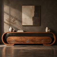 Corner detail of low tv stand with a looped frame and three wave carved fronts beside wood, brass and linen samples