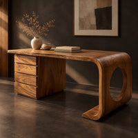 Corner detail of desk with a drawer pedestal and a curved leg with a round cutout beside wood, brass and linen samples