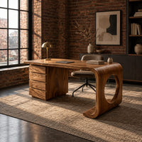 Desk with a drawer pedestal and a curved leg with a round cutout in an industrial loft home office with exposed brick