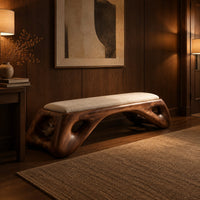 Cushioned bench with a sculpted wood arch base and oval cutouts in an evening entryway with walnut wall paneling