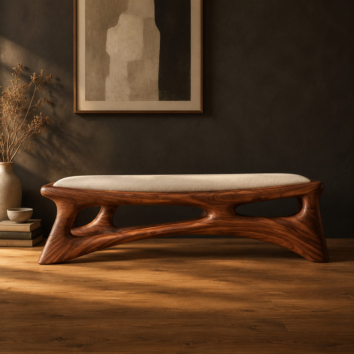 Cushioned bench with a carved open frame and slanted legs in a dark studio against a charcoal plaster wall